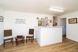 a room with two chairs and a table and a counter at Horseshoe Tourist Park in Wagga Wagga