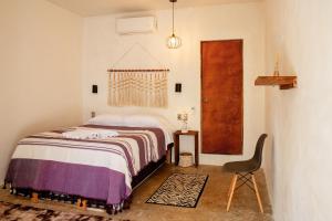 a bedroom with a bed and a chair at Casa OM Chakra in Brisas de Zicatela