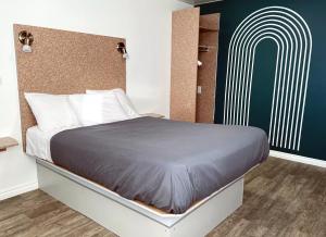 ein Schlafzimmer mit einem großen Bett und einer grünen Wand in der Unterkunft Motel Moreau in Saint-Félicien