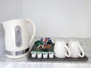 a counter with a tea kettle and cupcakes on a tray at The Beech Flat - Self contained one bedroom flat with parking in Oxford