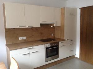 a kitchen with white cabinets and a stove at Ferienwohnung Blumen Penz in Zell am Ziller