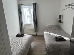 a bedroom with two beds and a window at Windsor stays 1 in Liverpool