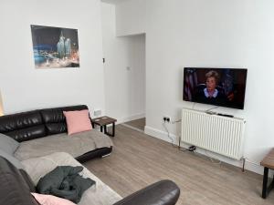 a living room with a couch and a flat screen tv at Windsor stays 1 in Liverpool
