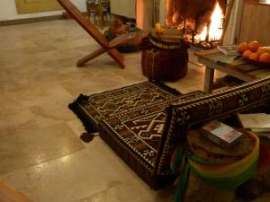 a living room with a fireplace and a table and a rug at maison d'art et d'autres in Champagne