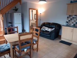 a living room with a table and a leather couch at Larchlodge in Ennis