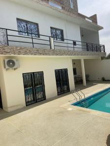 a house with a swimming pool in front of it at sembene tourisme ngaparou in Ngaparou