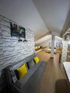 印摩澤魯德坎達的住宿－Cozy Studio Ain Soltane，带沙发和砖墙的客厅