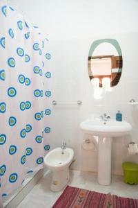 uma casa de banho com um lavatório, um WC e um espelho. em Simabo's Backpackers' Hostel em Mindelo