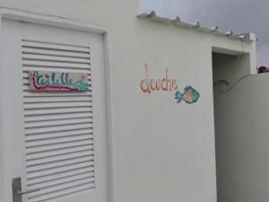 uma porta de garagem branca com duas placas em Simabo's Backpackers' Hostel em Mindelo