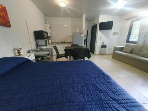 a bedroom with a blue bed and a living room at La Mary in Mendoza +3 photos