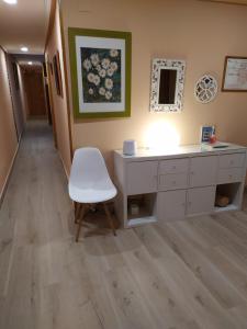 a room with a desk and a white chair at PENSIÓN PEÑA in Burgos +2 photos