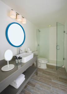 a bathroom with a toilet, sink, and shower at The Gates Hotel Key West in Key West