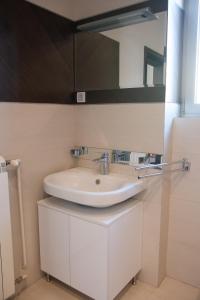 La salle de bains est pourvue d'un lavabo blanc et d'un miroir. dans l'établissement Square 6, à Belgrade