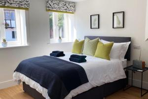 a bedroom with a large bed with yellow and blue pillows at New studio apartment - minutes walk to Cathedral in Salisbury