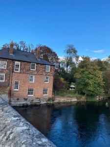 a large brick building next to a river at New studio apartment - minutes walk to Cathedral in Salisbury