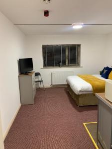 a bedroom with a bed and a tv in a room at Premium Inn Apartments in Methley