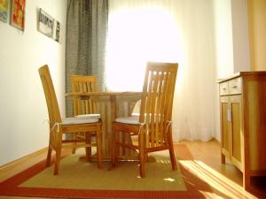 stół jadalny z 3 krzesłami i oknem w obiekcie Ferienwohnung Ottlinger w mieście Erbach