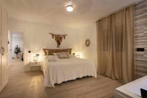 a bedroom with a white bed and a large window at Huellas de la Mancha in Burguillos de Toledo +57 photos