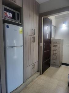 uma cozinha com um frigorífico e uma porta para um armário em R.504 Hermoso estudio, con cocina y baño privado. na Cidade do Panamá