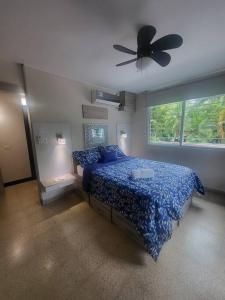 1 dormitorio con 1 cama azul y ventilador de techo en R.504 Hermoso estudio, con cocina y baño privado., en Panamá