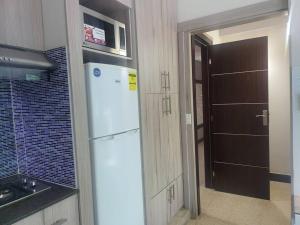 uma cozinha com um frigorífico branco e uma porta em R.504 Hermoso estudio, con cocina y baño privado. na Cidade do Panamá