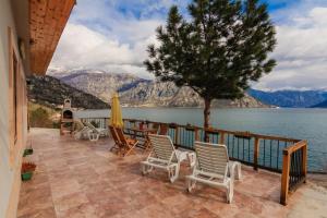 a patio with chairs and a table and a view of the water at Villa Strp in Risan