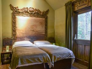 a bedroom with a bed with a painting on the wall at King Auberons-uk43000 in Upper Helmsley