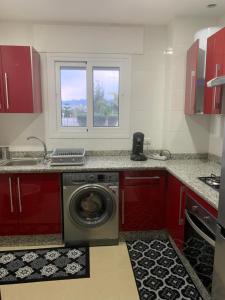 uma cozinha com uma máquina de lavar roupa e uma janela em Appartement de standing Résidence Kariat Cabo em Cabo Negro