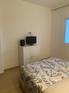 um quarto com uma cama e uma televisão na parede em Appartement de standing Résidence Kariat Cabo em Cabo Negro