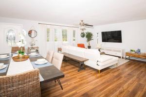 uma sala de estar com um sofá branco e uma mesa em Cozy Blue house blocks from beach with Private Pool, BBQ, Backyard em Deerfield Beach