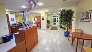 a lobby with a restaurant with a table and chairs at Hotel Amadeus Dresden Neustadt in Dresden