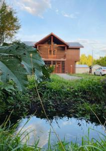 une maison en rondins avec une réflexion dans un étang dans l'établissement Hostal Treile, à Pucón