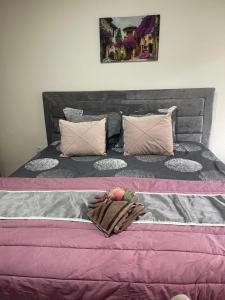 a large bed with pink and gray sheets and pillows at ALOHA apartment in Novi Pazar
