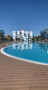 uma grande piscina em frente a alguns edifícios em Appartement de standing Résidence Kariat Cabo em Cabo Negro