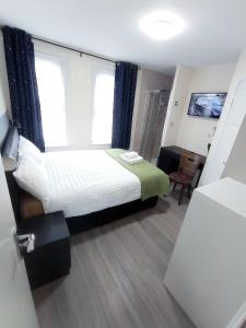 ein kleines Schlafzimmer mit einem Bett und einem Fenster in der Unterkunft The Maple Studio - Self contained one bed studio flat in Oxford