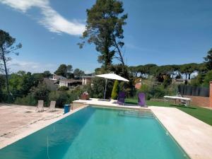 a swimming pool with chairs and an umbrella at Villa in Castellar del Riu with Pool & Pyrenees in Castellar del Riu