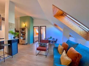 El Ático de Vigo في فيغو: غرفة معيشة مع أريكة زرقاء وطاولة