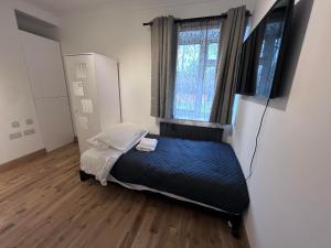 ein kleines Schlafzimmer mit einem Bett und einem Fenster in der Unterkunft N 25 in Horley