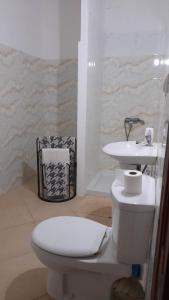 een badkamer met een wit toilet en een wastafel bij Stay at Kety's in Praia
