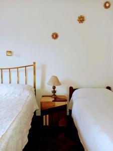 a bedroom with two beds and a lamp on a night stand at Hospedaje in Salta