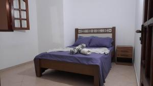 1 dormitorio con cama con sábanas moradas y almohadas azules en Stay at Kety's, en Praia