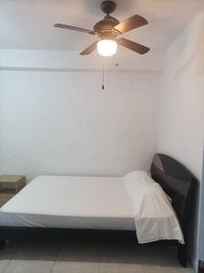 1 dormitorio con 1 cama y ventilador de techo en Hermoso y cómodo apartaestudio!, en Barranquilla