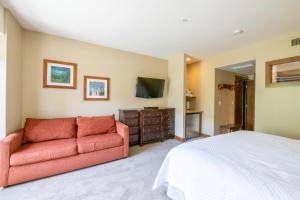 a bedroom with a bed and a red couch at Ski In Ski Out Conde Nast and Forbes Award Winner Three Bedroom Pool Hot Tub Gym in Park City