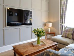 a living room with a coffee table and a tv at Cardoness House in Dumfries