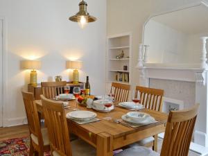 a dining room with a wooden table and chairs at Cardoness House in Dumfries