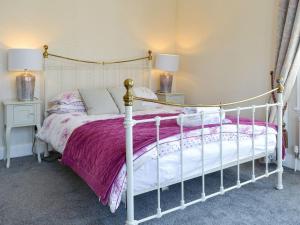 a bedroom with a white bed with a purple blanket at Cardoness House in Dumfries