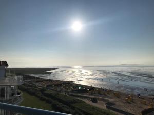 ein Blick auf den Strand vom Balkon eines Gebäudes in der Unterkunft Silbermöwe - Traumhafter Meerblick in Cuxhaven