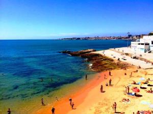 a group of people on a beach near the ocean at IN-Cascais Suite Deluxe com pátio privado in Cascais