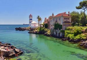 a house on the shore of a river with a lighthouse at IN-Cascais Suite Deluxe com pátio privado in Cascais