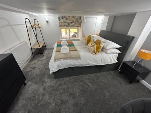 una camera da letto con un grande letto con cuscini gialli e bianchi di Airport Hideaway a Manchester